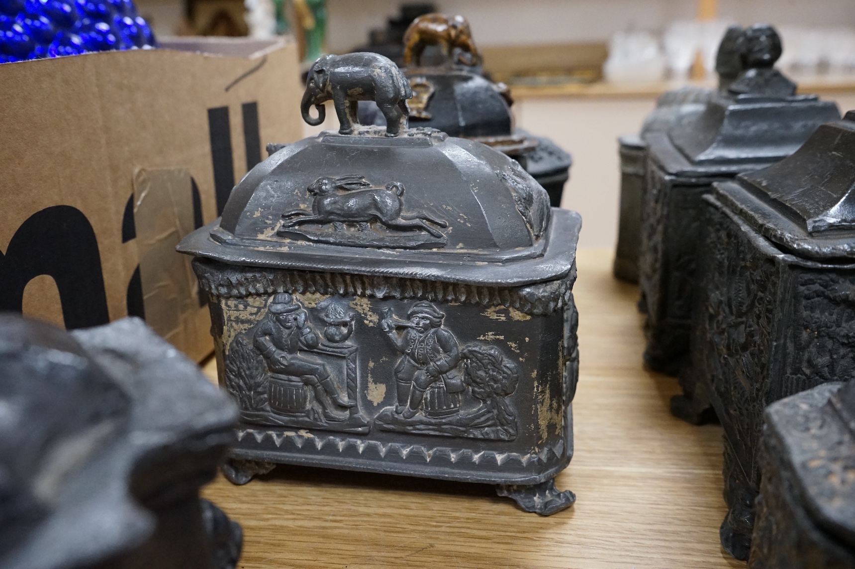 A collection of ten early 19th century lead tobacco boxes, one in the form of a monument with lion knop, largest 14cm wide